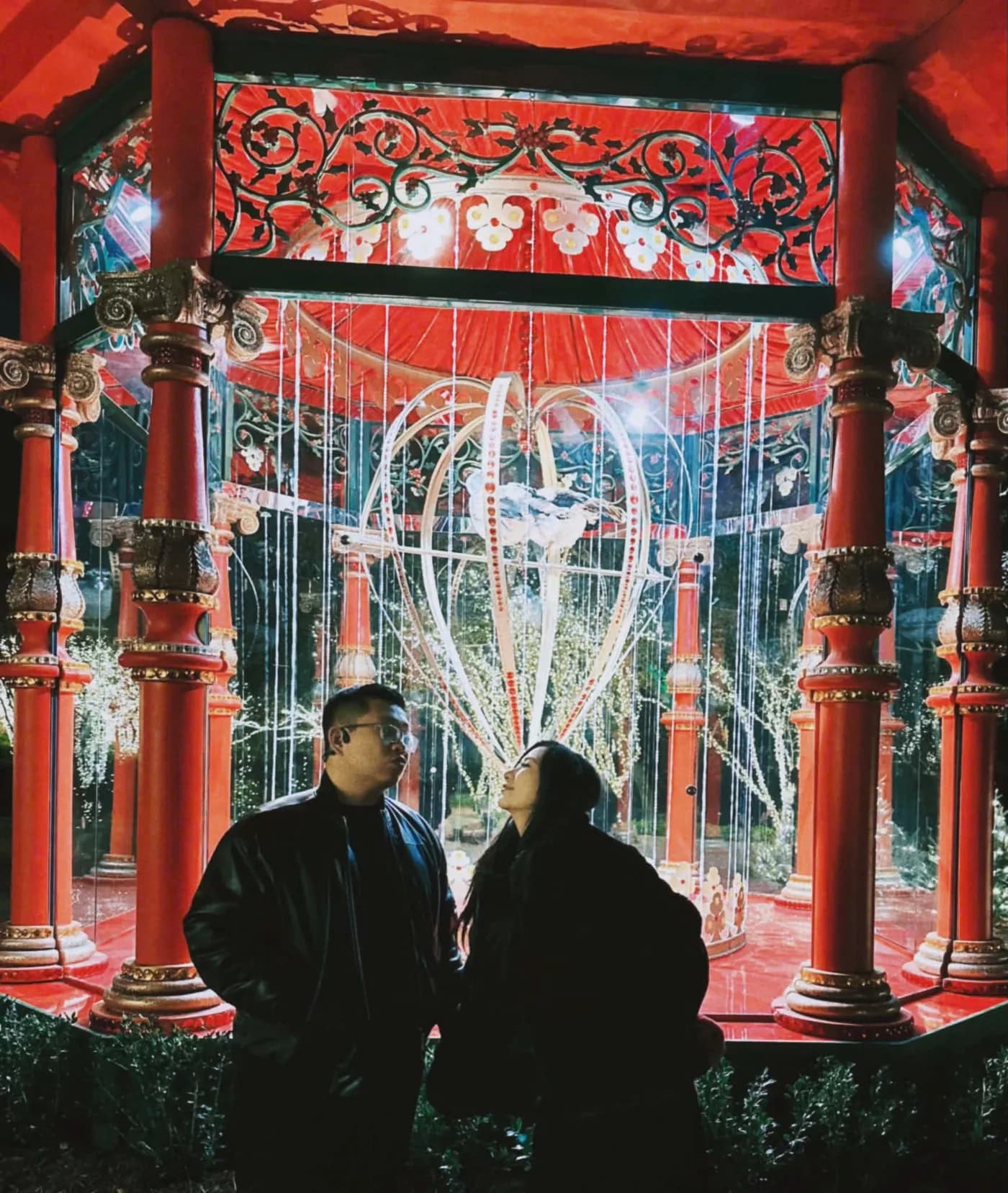 Hong Hanh and Tri Anh beneath a red ceremonial arch